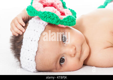 Ein Baby Mädchen mit einem gehäkelten Kopfbügel Stockfoto