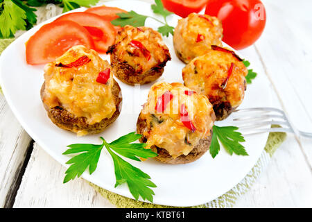 Champignons gefüllt mit Fleisch und Paprika in der Platte an Bord Stockfoto