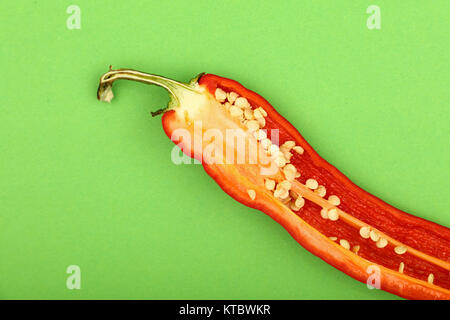 Ein cut Red Hot Chili Pepper auf grünem Hintergrund Stockfoto