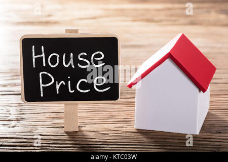 Text Haus Preis auf Tafel mit einem Haus Modell geschrieben Stockfoto