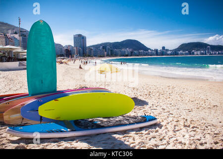 RIO DE JANEIRO, BRASILIEN - 24. APRIL 2015: Surfbrett und Brasilianer am 24. April 2015 am Strand von Copacabana, Rio de Janeiro. Brasilien. Stockfoto