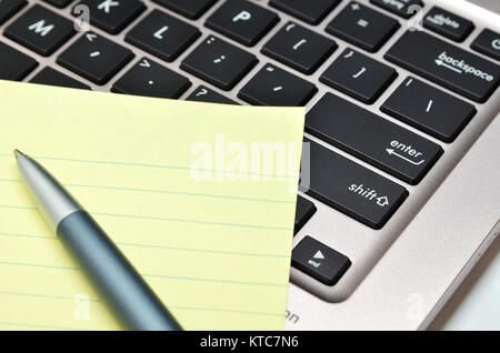 Notizblock und Stift auf der Tastatur, schwarz Stockfoto