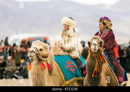 Aisholpan der Adler Jägerin und anderen Camel Rider im Golden Eagle Festival in der Mongolei Stockfoto