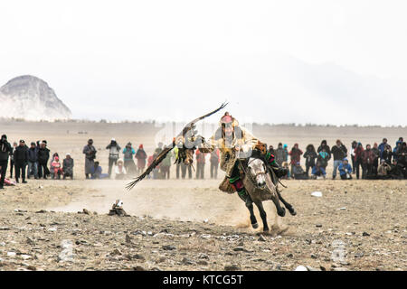 Kasachischen eagle Jäger zu Pferd im Golden Eagle Festival in der Mongolei konkurrierenden Stockfoto