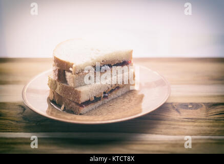 Peanut Butter und Marmelade Sandwich auf Weißbrot, halbiert und gestapelt. Auf kleinen vintage Platte gezeigt Stockfoto