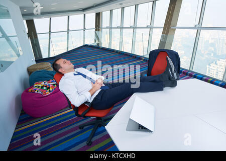 Young Business Mann schläft auf dem Schreibtisch Stockfoto