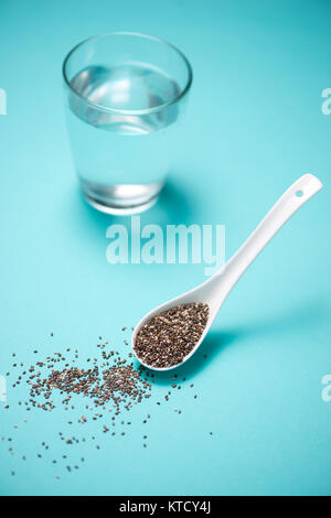 Glas Wasser und gesunde Chia-Samen in einem Löffel. Text-Raum. Stockfoto