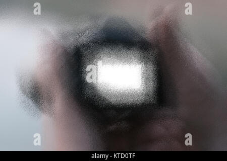 Eine menschliche Hand, die eine DSLR-Kamera mit Objektiv verwischen. Stockfoto