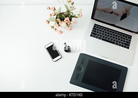 Arbeitsbereich der professionellen Retoucher. Laptop, Topf Blume, Stift und Tablett für die Retusche. Arbeitsbereich der professionellen Retoucher. Stockfoto