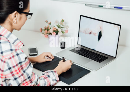 Frau Retusche am Computer mit digitalen Tablet und Stylus Stift Laptop Stockfoto