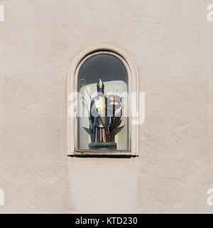 Skulptur des Heiligen Nikolaus auf einer Hauswand in Regensburg, Deutschland Stockfoto