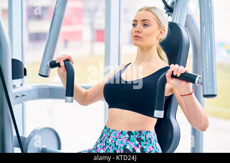 Schöne passende Frau arbeitet in einem Fitnessstudio Stockfoto