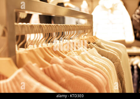 Rosa Kleidung der Frauen auf Holz Kleiderbügel auf Rack in Fashion Store. Schrank Frauen Pullover Nahaufnahme Stockfoto