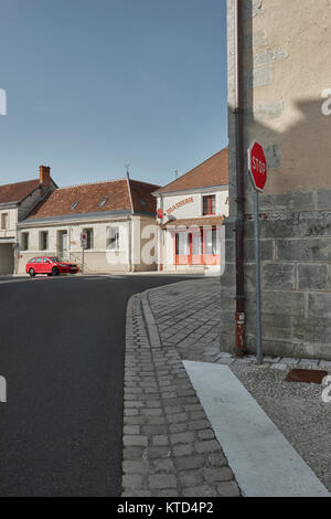 Ein rotes Auto und ein rotes Stoppschild im ruhigen Stadtzentrum von genille in das Tal der Loire in der Nähe von Nogent-le-Rotrou Frankreich. Stockfoto
