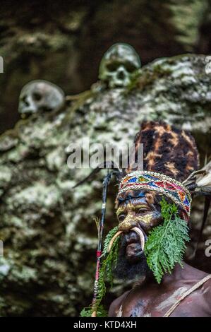 Neuguinea, Indonesien - 12. Januar: Mann mit Pfeil und Bogen. Der Krieger der Papuanischen Stamm Yafi in traditioneller Kleidung, Schmuck und Färbung. Ne Stockfoto