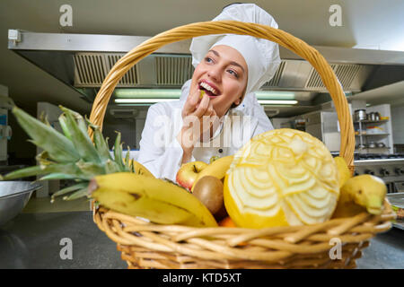 Portrait von Happy Köchin garnieren auf Lebensmittel in der gewerblichen Küche Stockfoto