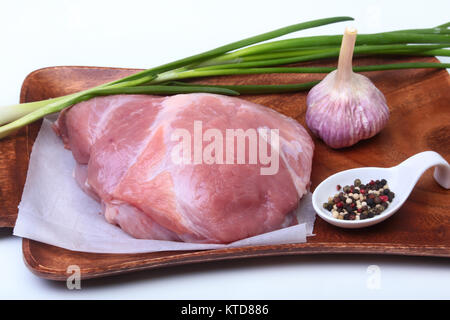 Schweinesteaks mit Fett. Fleisch ist auf Holzbrett mit Gewürze wie Pfeffer und grünen Frühlingszwiebeln. Bereit für das Kochen. Selektive konzentrieren. Stockfoto