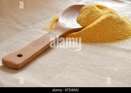 Stapel von organischem Getreide Körner und einem Holzlöffel auf grobem Tuch. Vorbereitete Zutaten zum Kochen. Stockfoto