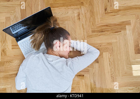 Eine Frau schläft auf dem Laptop. Stockfoto