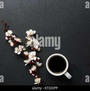 Tasse Kaffee und Blumen auf rosa Holztisch. Stockfoto