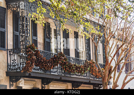 Magnolia Weihnachten roping schmückt die schmiedeeisernen Balkon in einem historischen Haus an der Church Street in Charleston, SC eingerichtet. Stockfoto