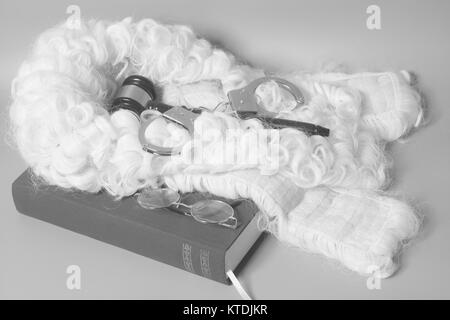 Für Richter: Richter Perücke, Handschellen, Richter Hammer, Buch Ende Brillen auf grauem Hintergrund Stockfoto