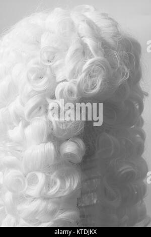 Perücke auf einem grauen Hintergrund beurteilen. Stockfoto