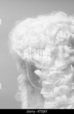 Perücke auf einem grauen Hintergrund beurteilen. Stockfoto