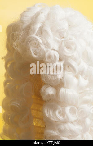 Perücke auf gelbem Hintergrund beurteilen. Stockfoto