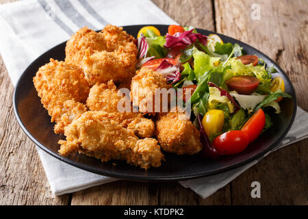 Fried Chicken Wings in Paniermehl und frisches Gemüse Salat close-up auf einem Teller. Horizontale Stockfoto