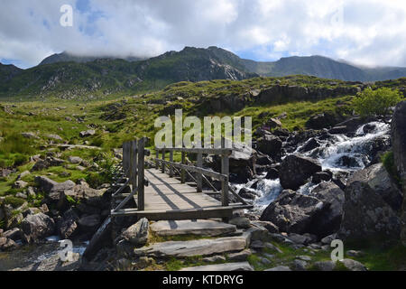 Brücke über Stream am Llyn Ogwen Richtung Mount Tryfan, Snowdonia, Wales, Großbritannien Stockfoto