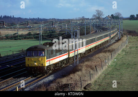 Klasse 86 elektrische Lokomotive Nummer 86256 mit einer passenden Rake von InterCity Coaches nördlich entlang der Wcml an Soulbury. 5. Februar 1997. Stockfoto