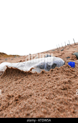 Abgebrochene Kunststoff Flasche Wasser am Strand links und bedeckt mit Sand