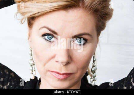 Horizontale Portrait von blonde Frau mit großen Ohrringe auf weißem Hintergrund Stockfoto