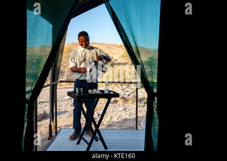 Mitarbeiter servieren Kaffee in Huab unter Leinwand, Damaraland, Namibia, Afrika Stockfoto