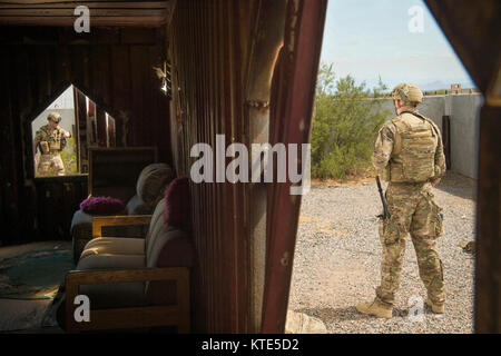 Staff Sgt. Brandon Holz, 56. Bauingenieur Squadron die Beseitigung von Explosivstoffen team leader, (links) Löscht ein Bereich der möglichen simulierten Improvised Explosive Devices als Flieger 1. Klasse Zachary Riesselmann, 56. CES EOD Team Mitglied, steht im Florenz militärischen Reservierung in Florenz, Ariz., 21. Juli 2017 klar. Die beiden Piloten met ihr Ziel nach dem Suchen und Unscharfschalten einer während eines Tages IED - lange ausüben. Stockfoto