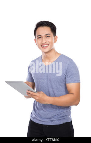 Jungen asiatischen Mann mit einem digitalen Touchscreen Tablet Computer o Stockfoto