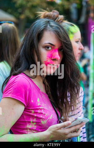 Lemberg, Ukraine - 30. August 2015: Mädchen mit Smartphone ansehen Festival der Farben in einem Stadtpark in Lemberg. Stockfoto