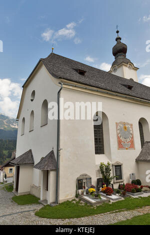 HAUS, Österreich - 24 September 2017: Alte ländliche alpine Friedhof in der Nähe von St. Johannes der Täufer Kirche mit Sonnenuhr. Haus Village ist eine kleine winter Reso Stockfoto