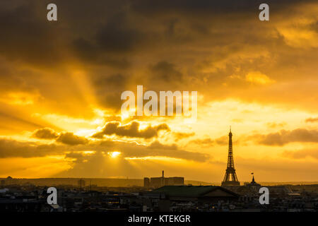 Stadtbild von einer flammenden Sonnenuntergang über der Skyline von Paris mit der Silhouette des Eiffel Turm, gegen einen roten stürmischen Himmel. Stockfoto