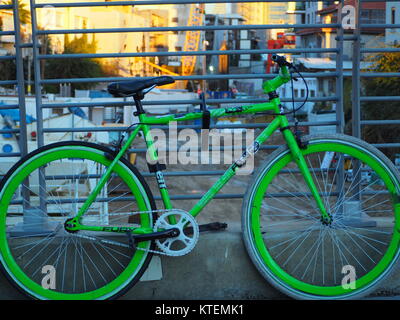 Grünlich Stadt Single Speed bike Parken auf Brücke u gesperrt Geländer Stockfoto