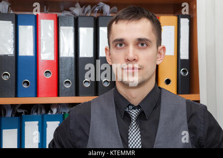 Kaukasische finanzielle recordkeeper vor einem Schaltschrank mit Farbe Dokumentation Ordner Stockfoto