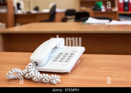 Weiss schnurgebundenes Telefon stehen auf Holz- büro Schreibtisch, leeren Raum Stockfoto