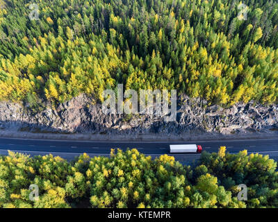 Ansicht von oben auf die weißen Sattelzug fahren zwischen Rock tunnel im Herbst Wälder von Karelien, Russland Stockfoto