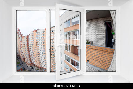 Triple-casement pvc-fenster mit Blick auf die Fassade des Multi-Wohnung mit Balkon Stockfoto