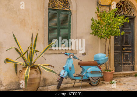 Die Stadt Korfu Griechenland. Architektur in der Altstadt von Korfu ist stark mein der Venezianischen Architektur. Blaue Vespa außerhalb eines Gebäudes beeinflusst. Stockfoto