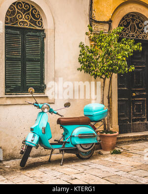 Die Stadt Korfu Griechenland. Architektur in der Altstadt von Korfu ist stark mein der Venezianischen Architektur. Blaue Vespa außerhalb eines Gebäudes beeinflusst. Stockfoto