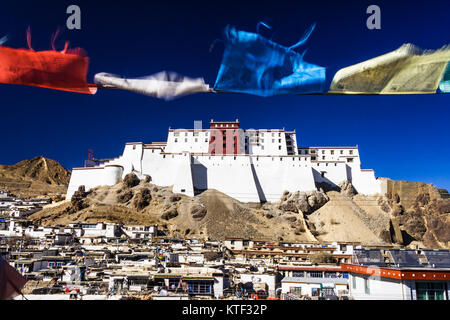 Ansicht der wiederaufgebauten Dzong von Shigatse oder Samdruptse Dzong mit Gebetsfahnen im Vordergrund. Shigatse, Tibet Stockfoto