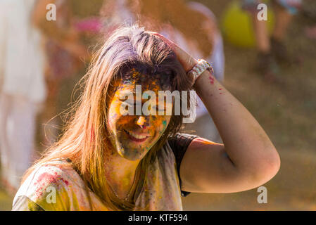 Lemberg, Ukraine - 28. August 2016: fröhliches Mädchen in Farbe Pulver streichelt ihr Haar während des Festivals der Farbe in einem Stadtpark in Lemberg. Stockfoto