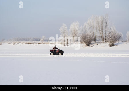 Nicht identifizierte Motocross Fahrer auf Quad Motocross saison Rennen zu öffnen. winter Motocross. ATVs sind Reiten in das Feld im Schnee auf der backgrou Stockfoto